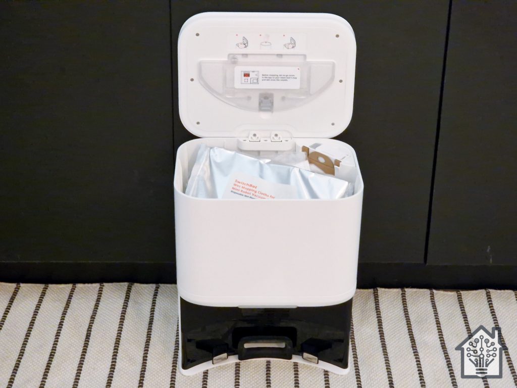 SwitchBot K10+ robot vacuum's docking station, showing the mopping module, wet wipe pack, and dust bag